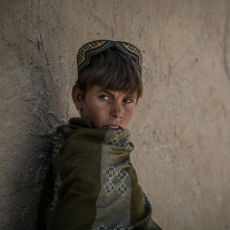 Afghan boy pressed against a wall